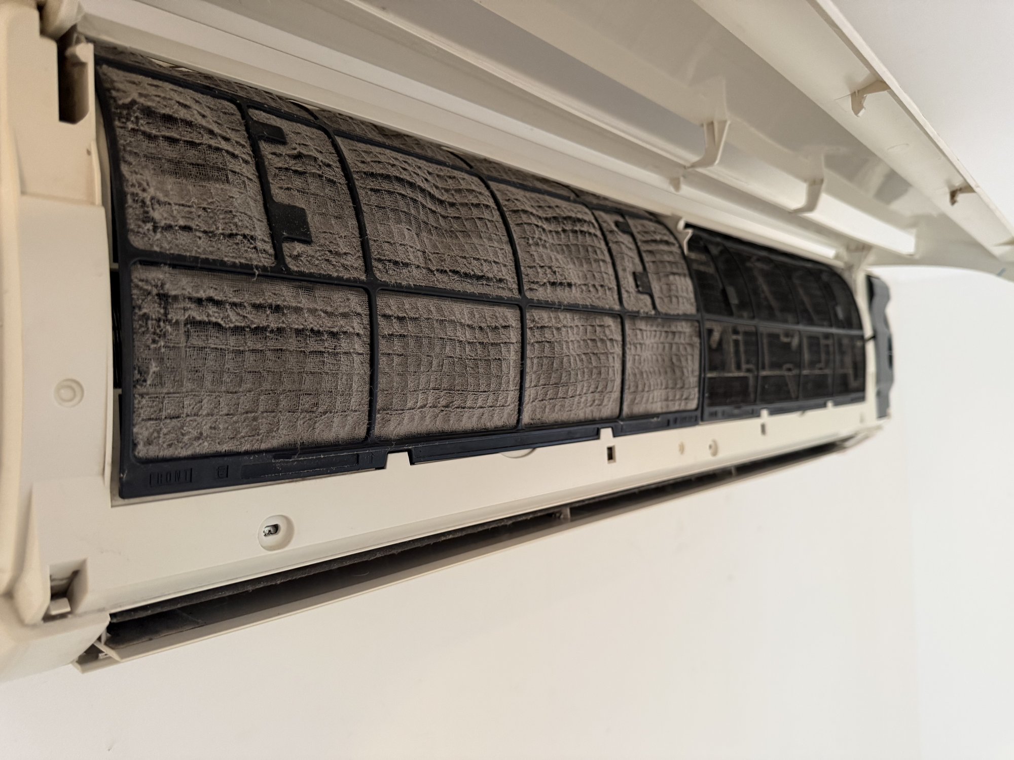 Dirty, dust-clogged air conditioner filter before professional cleaning in Townsville